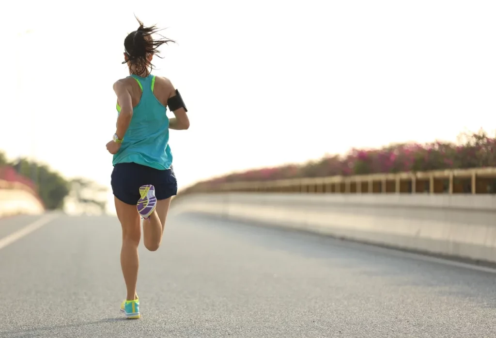 a woman jogging on a road.