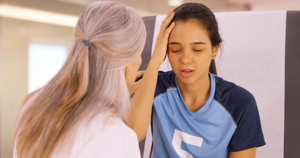 a woman is looking at her head in a mirror.