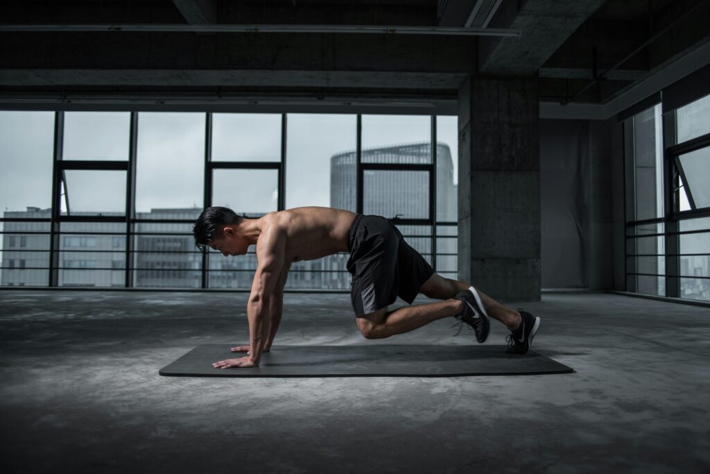 Man performing push-up climbers exercise, combining core and upper body work as part of bodyweight strength training